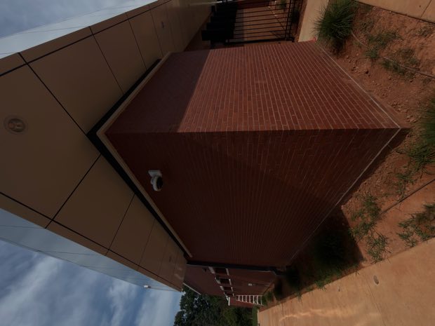 Camera mounted at the roofline of a brick building