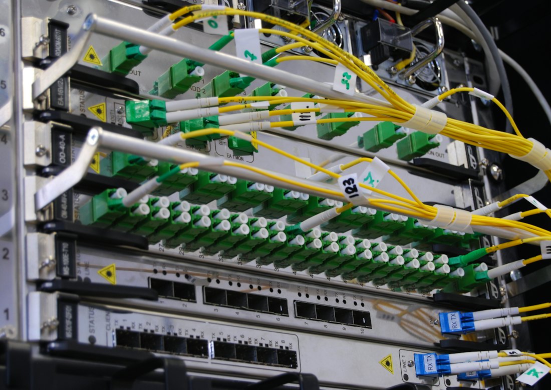 Fiber optic cables patched into a network switch in a rack