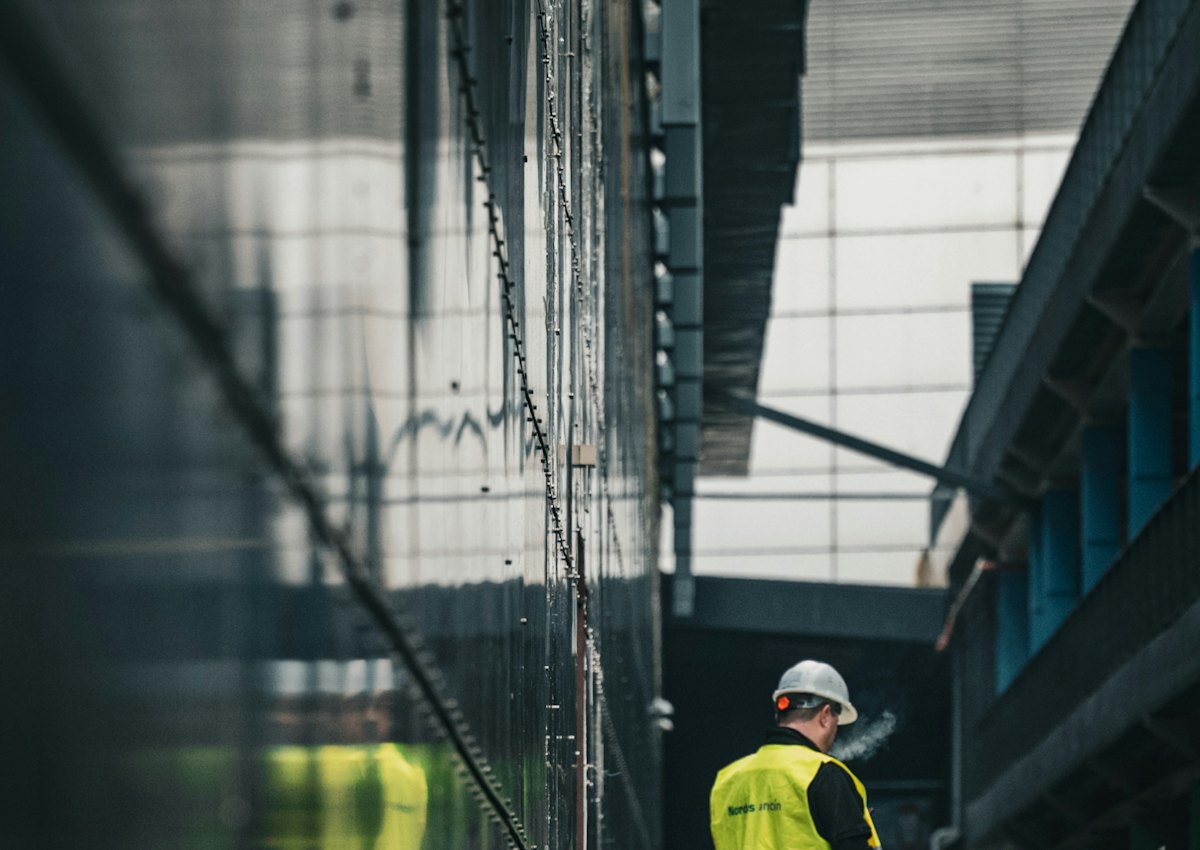 Installer in a high-visibility vest walking an active construction site